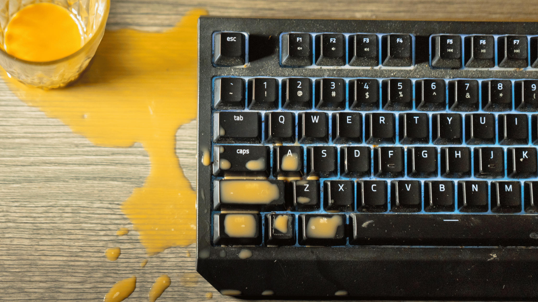 orange juice spilling on a mechanical keyboard for gaming